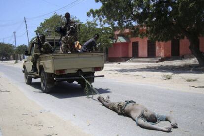 Soldados gubernamentales arrastran el cadáver de un miliciano del grupo islamista Al Shabab.