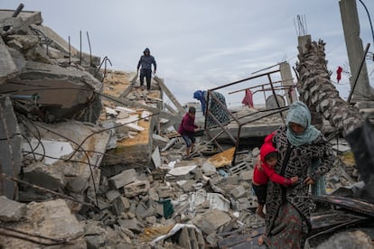 Ciudadanos palestinos trasladan buscan entre los escombros de sus casas destruidas por los ataques israelíes en Yabalia, en la franja de Gaza, este jueves.