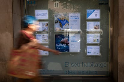 Una mujer pasa frente a una inmobiliaria en Barcelona.