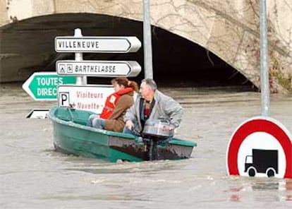 Residentes de Aviñón recorren en una barca una calle de la ciudad francesa, anegada por las aguas.