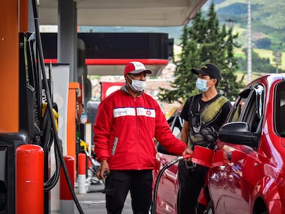 Un trabajador llena el tanque del auto de un cliente, en Nariño, en 2021.