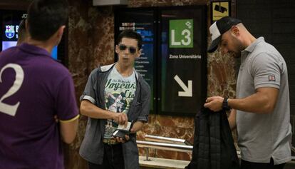 Dos guardas urbanos registran a un presunto carterista en el metro de Barcelona.