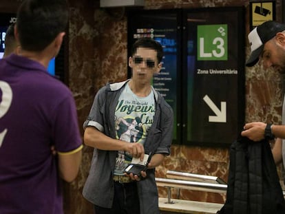 Dos guardas urbanos registran a un presunto carterista en el metro de Barcelona.