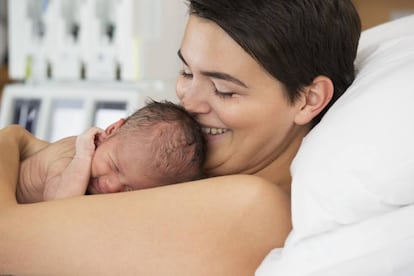 Una madre coge su recién nacido en brazos.
