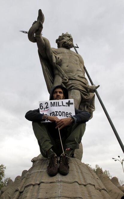 Un manifestante junto a la estatua de Neptuno durante la protesta que llama a "asediar" el Congreso de los Diputados.