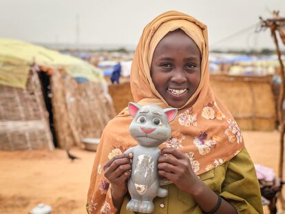 Mushtaha, de 10 años, sostenía en las manos a su muñeco Tom, el 17 de julio en el campo de refugiados de Adré, en Chad. Tom es uno de los pocos juguetes que ella y sus cinco hermanos consiguieron llevarse cuando huyeron de El Geneina el año pasado. "Antes hablaba de verdad, pero ahora no tenemos pilas", dice. Cuando le preguntan cómo es vivir en el campo, no se lo piensa dos veces: "¡Nada bien!", es su respuesta. Ir a la escuela es lo que más echa de menos. "¿Por qué no hay escuela aquí?", se pregunta la niña.