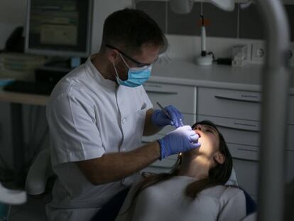 Un dentista amb una pacient a la seva consulta.