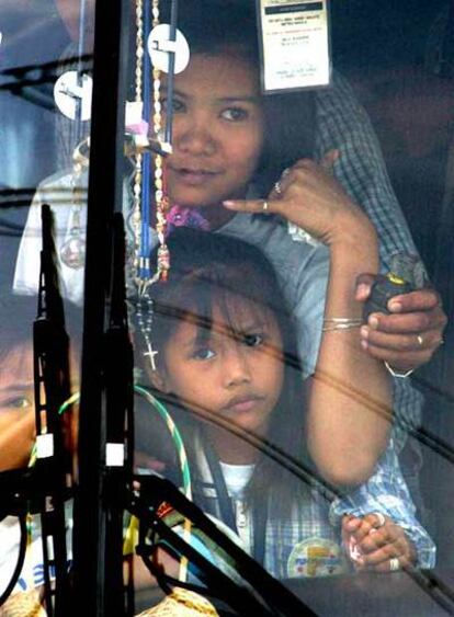 Una profesora secuestrada en el autobús en Manila pide un móvil a la policía miestras el secuestrador mantienen la granada a su lado.