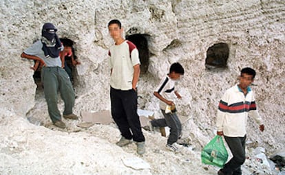 Menores marroquíes, ante la cueva en la que viven en los acantilados de Melilla.