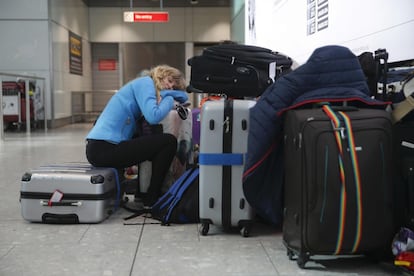 Una viajera duerme junto a sus maletas en la Terminal 5 del aeropuerto de Heathrow después de la cancelación de los vuelos de British Airways.