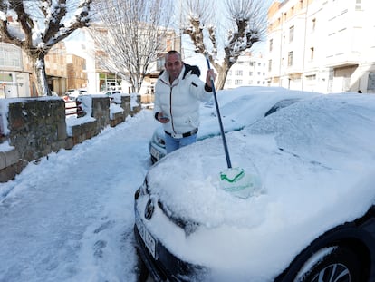 Una persona retira la nieve de un coche en una calle de Soria, este sábado.