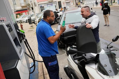 Dos hombres hablan en una gasolinera en Lisboa este martes, tras restablecerse todos los suministros tras el apagón.