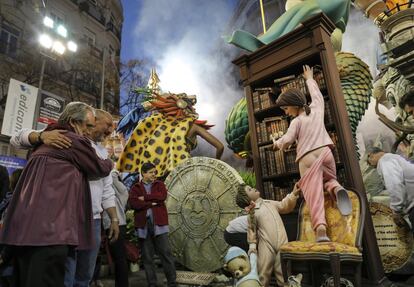 Dos artistas falleros se abrazan mientras observan el ninot individual de este año de la calle Almirante Cadarso-Conde Altea.