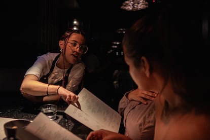 A bartender gives drink recommendations to customers.