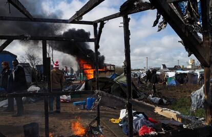 Tiendas improvisadas del campamento de Calais arden mientras la policía los desaloja este jueves.