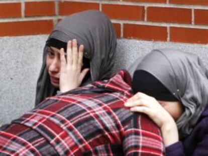 Tres mujeres lloran a las puertas de la casa donde ha sido asesinada la mujer.
