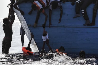 Migrantes tratan de salvar a la desesperada a un ni&ntilde;o en el agua 