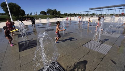 Unos niños se refrescan en las fuentes de un parque de Madrid.