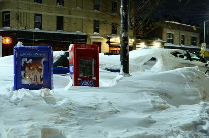 Buzones dispensadores de prensa en 2016 en un Nueva York nevado. A la derecha, el de 'The Village voice'.