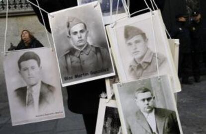 Un manifestante porta los retratos de víctimas del franquismo a las puertas del Tribunal Supremo.