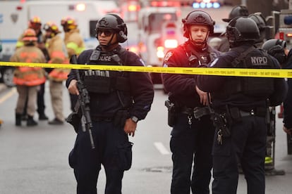 Varios policías en una calle cortada tras el suceso en el metro de Nueva York. Las autoridades han pedido a la ciudadanía que eviten transitar por la zona, acordonada por camiones de bomberos y vehículos de las fuerzas del orden, además de un visible despliegue de agentes con armamento pesado.