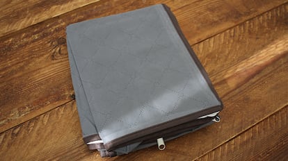 Bolsas de plástico para guardar ropa sobre una mesa de madera.