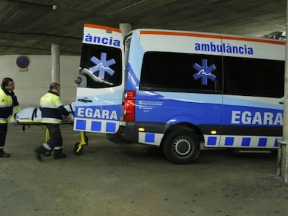 Dos treballadors al costat d'una ambulància a Terrassa.