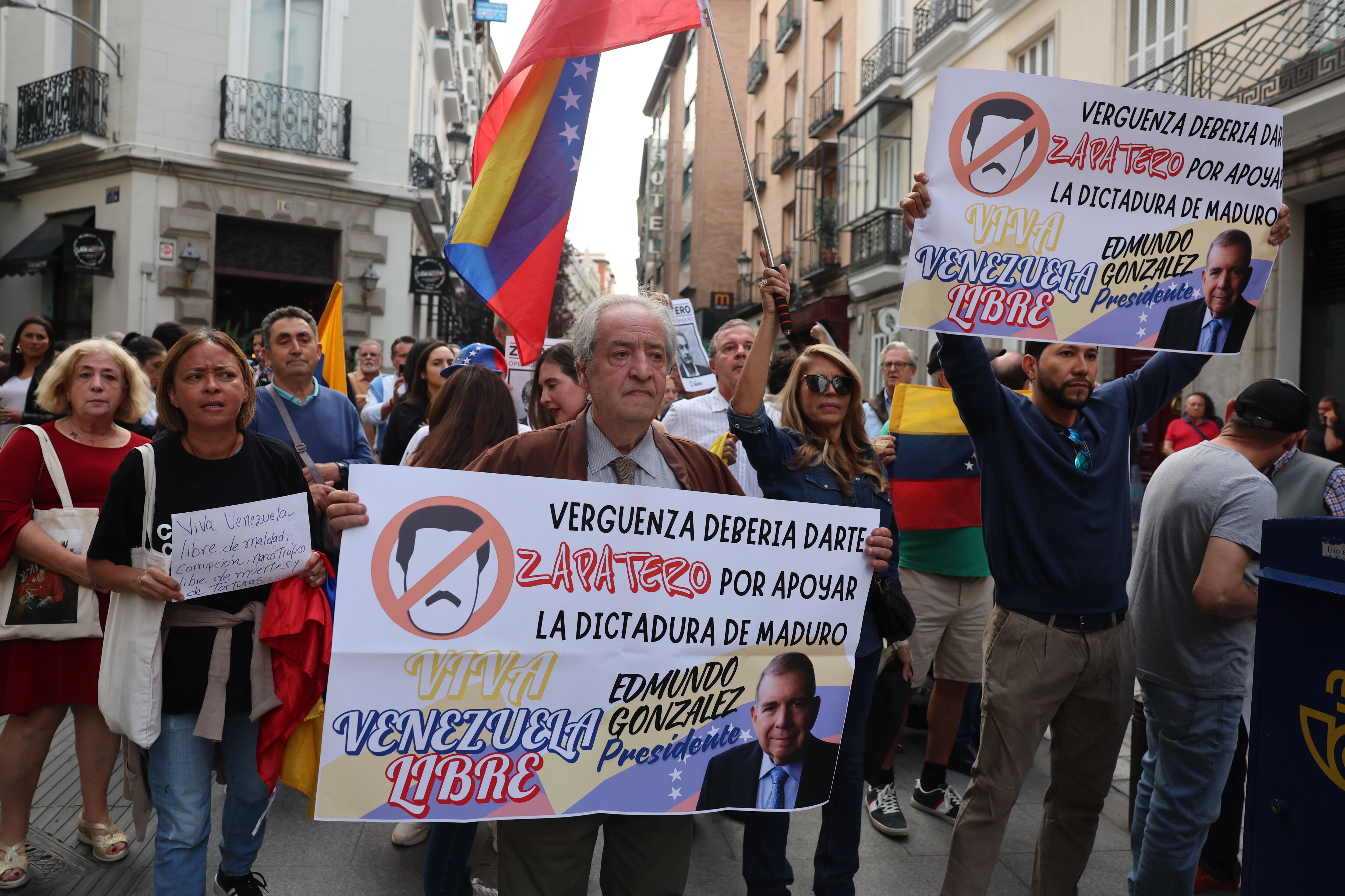 Varios manifestantes protestan contra el expresidente del Gobierno José Luis Rodríguez Zapatero, este martes en los alrededores del Ateneo de Madrid. 