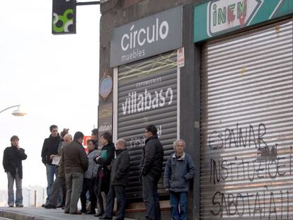 Varias personas hacen cola ante una oficina del INEM en Bilbao.