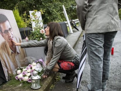 La viuda de Eduardo Puelles deposita flores en el lugar donde fue asesinado su marido.