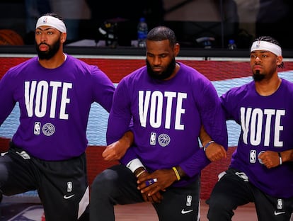 Anthony Davis, LeBron James y Quinn Cook, de los Lakers, con el lema “Vota” en sus camisetas.