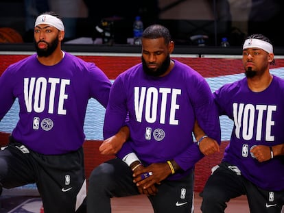 Anthony Davis, LeBron James y Quinn Cook, de los Lakers, con el lema “Vota” en sus camisetas.