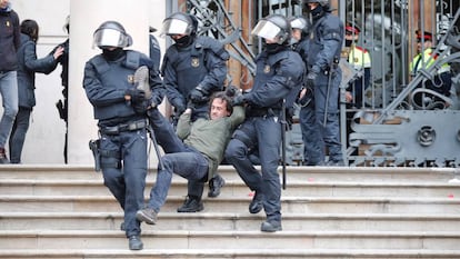 Agentes antidisturbios desalojan a uno de los manifestantes.