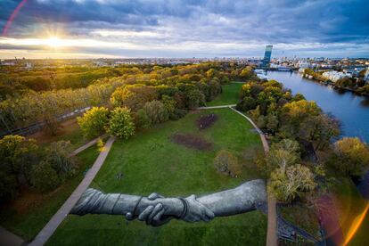 Vista aérea de una pintura gigante biodegradable del artista franco-suizo  Saype representando dos manos juntas, en el parque Treptower de Berlín (Alemania). 