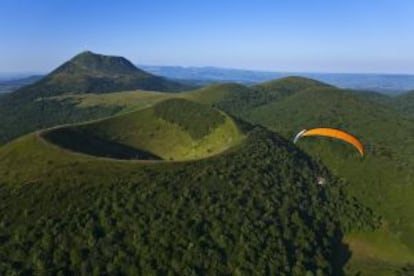 Vuelo en paramotor sobre el cráter del Puy Pariou, con el Puy de Dome al fondo, en la región francesa de Auvernia.