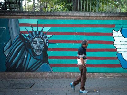 Un hombre camina junto a un mural antiamericano en Teherán.