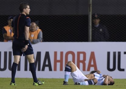 Carlos Tévez queda en el suelo después de un choque en el área de Paraguay.