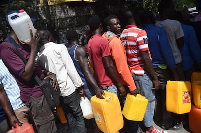 Durante o final da semana, foi proposta uma espécie de trégua, que permitia aos haitianos saírem para comprar água e comida. Bancos, postos de combustível e muitas empresas reabriram suas portas, depois de estarem fechadas nos últimos dias por saques, o que causou grandes prejuízos. Na foto, as pessoas esperam na fila para pegar combustível na comuna de Petion Ville, na capital haitiana, em 17 de fevereiro.