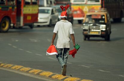 Un vendedor ambulante indio camina por una carretera de Bombay, India.