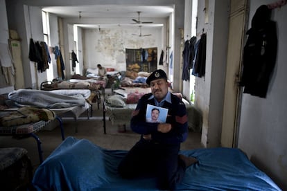 El policía, Asif Mian, de 44 años, con la foto de su compañero Muhammad Riaz, de 46 años. Asif se sienta en la cama de su amigo abrazando su fotografía, dentro de un dormitorio de la comisaría de Islamabad (Pakistán). "He perdido una parte de mí después de la muerte de Mahoma, que era mi brazo derecho", dice Mian.