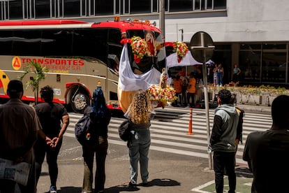 Varias personas observan el desfile de buses y camiones este miércoles en Medellín.


