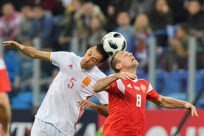 El jugador de la selección española, Sergio Busquets, y el jugador del combinado ruso, Denis Glushakov, tratan de hacerse con la posesión del balón en una acción del partido.