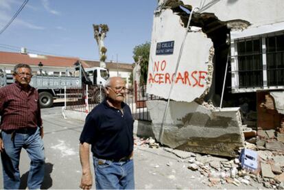 Dos vecinos de Lorca posan junto a un edificio destruido por el terremoto.