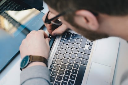 Un hombre repara una computadora