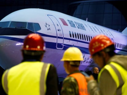 Grupo de trabalhadores diante de um Boeing 737 Max 8 da Air China, em uma imagem de arquivo. Em vídeo, morrem os 157 ocupantes da aeronave acidentada.