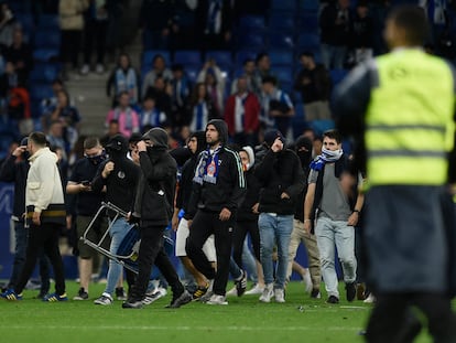 Algunos aficionados del Espanyol invaden el campo para impedir que los jugadores del Barça celebrasen el título de Liga sobre el césped del RCDE Stadium.