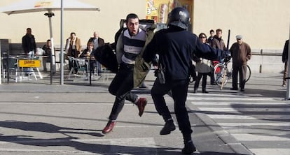 Un policía antidisturbios golpea con su porra a Jorge Navarro, uno de los detenidos que ha pasado a disposición judicial.