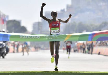 Jemima Jelagat Sumgong levanta los brazos en señal de victoria mientras cruza la línea de meta de la Maratón femenina en los Juegos Olímpicos de Río 2016 en el Sambódromo de Río de Janeiro.