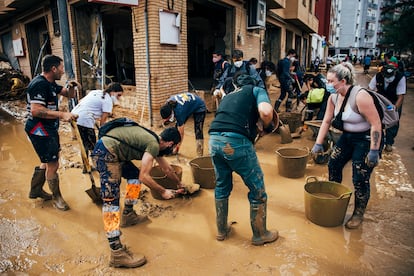 Unos voluntarios limpiaban una calle de Paiporta el jueves 8 de noviembre.