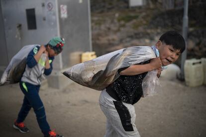 Dos niños llevan bolsas de plástico llenas de peces en Kulusuk (Groenlandia), el 15 de agosto de 2019. Según los residentes locales, el invierno —que solía durar hasta 10 meses— ahora puede ser tan corto como cinco meses. Pero el impacto climático sobre Groenlandia no ha diezmado el interés Donald Trump para intentar hacerse con el territorio autónomo perteneciente al reino de Dinamarca.